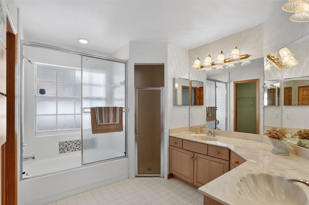 4995 Brook Road Kissimmee, FL 34758 - Photo 16 of 46 a spacious bathroom with a granite countertop sink mirror and bathtub