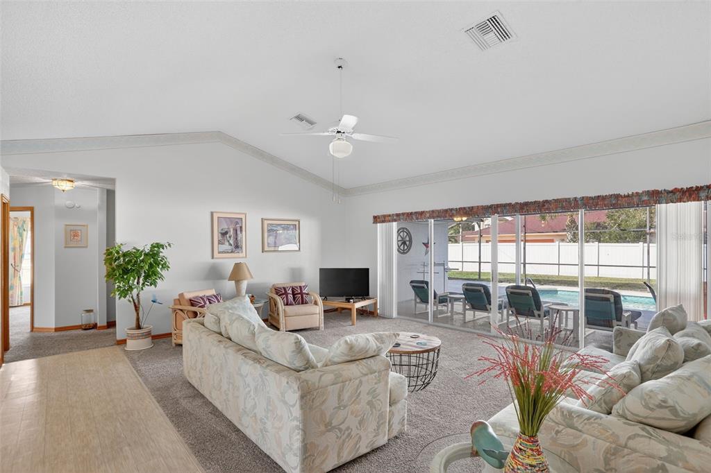 4995 Brook Road Kissimmee, FL 34758 - Photo 4 of 46 a living room with furniture a flat screen tv and a floor to ceiling window