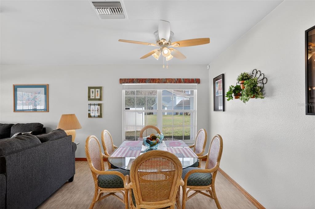 4995 Brook Road Kissimmee, FL 34758 - Photo 8 of 46 a dining room with furniture a chandelier and wooden floor