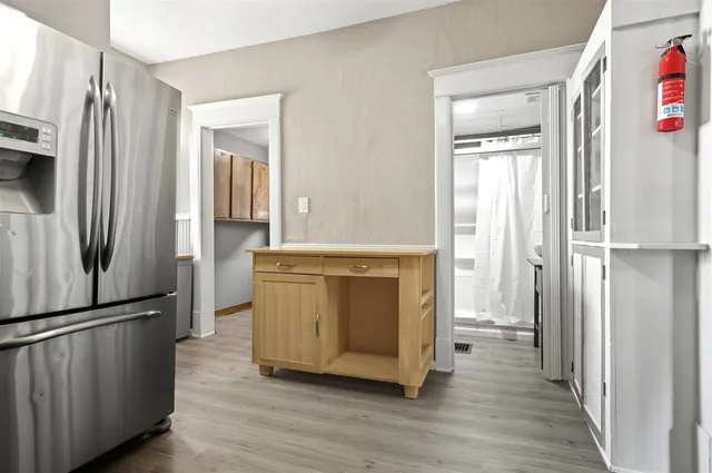 an empty room with wooden floor closet and windows
