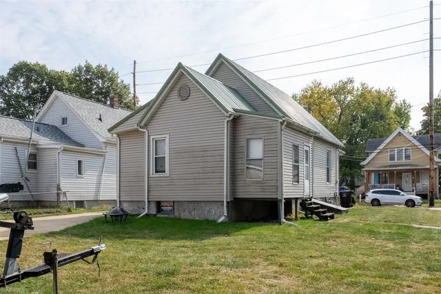 a front view of a house with a yard and trees