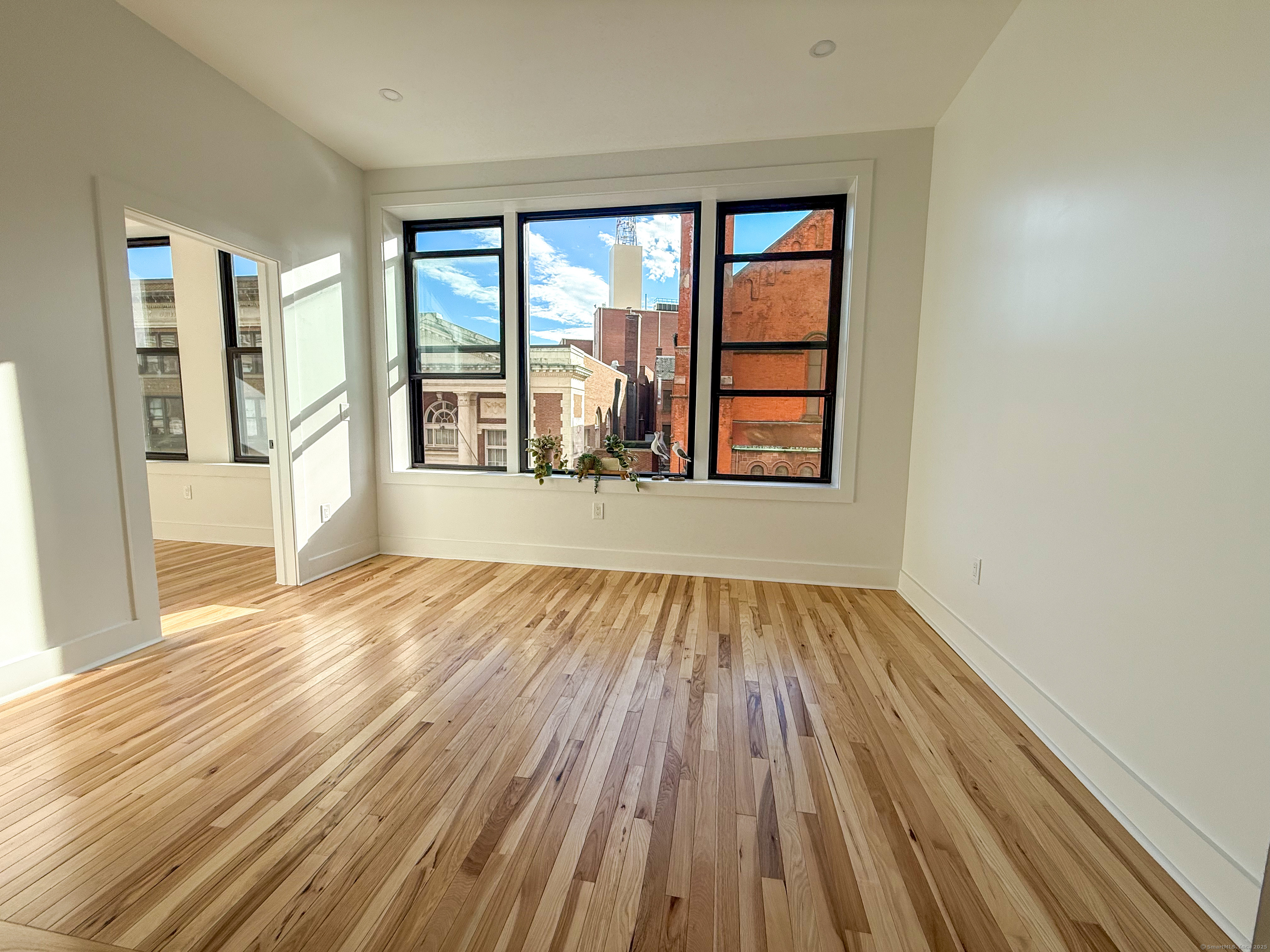 253 State Street, Unit 2L New London, CT 06320 - Photo 2 of 8 wooden floor in an empty room with a window