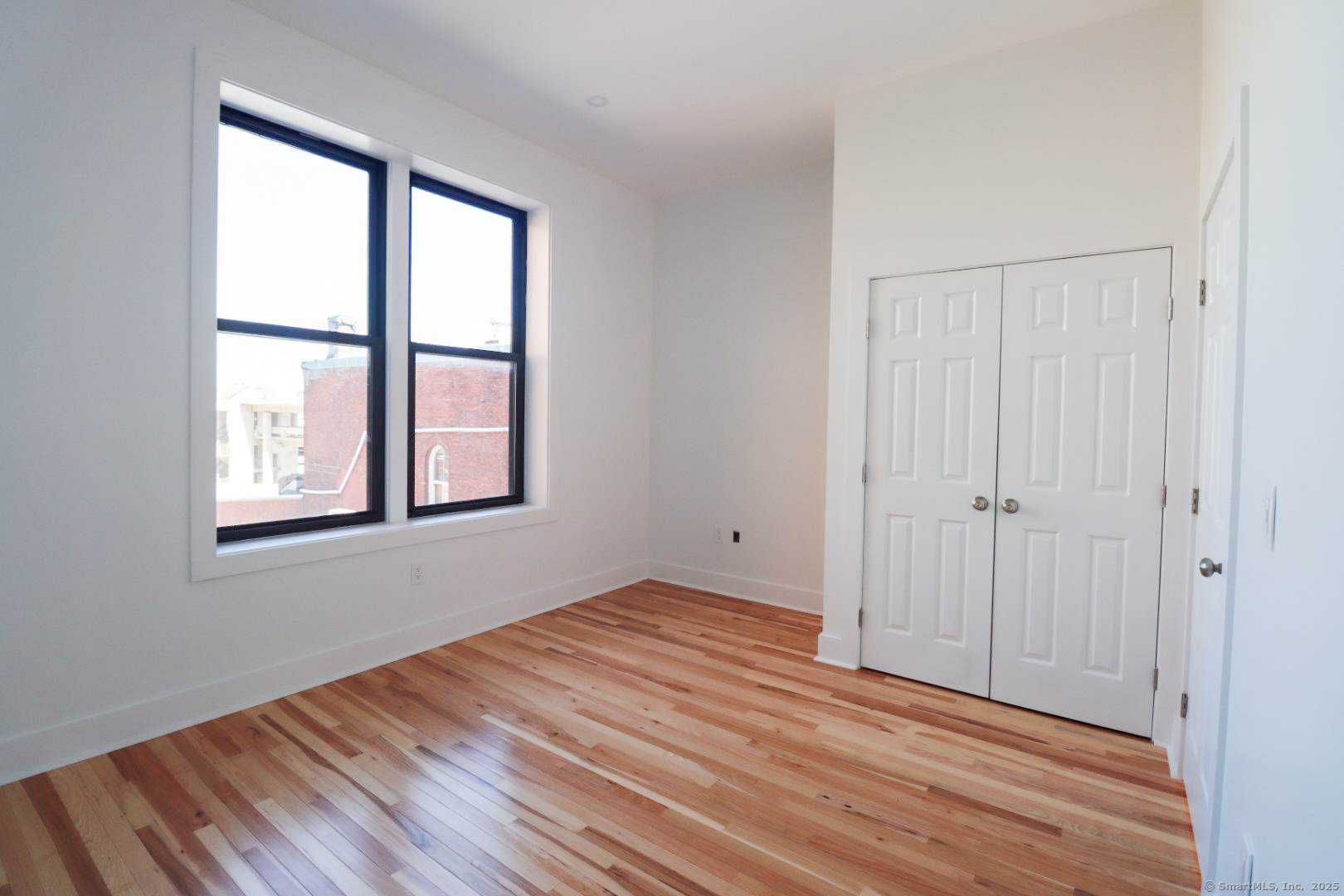 253 State Street, Unit 2L New London, CT 06320 - Photo 7 of 8 a view of an empty room with wooden floor and a window