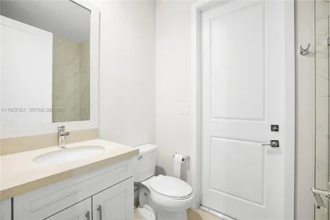 a bathroom with a sink a toilet and a mirror
