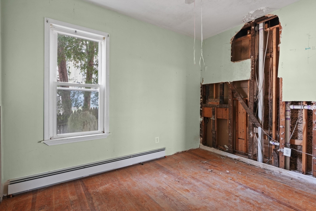 213 Weetamoe Street Fall River, MA 02720 - Photo 20 of 34 an empty room with wooden floor and windows