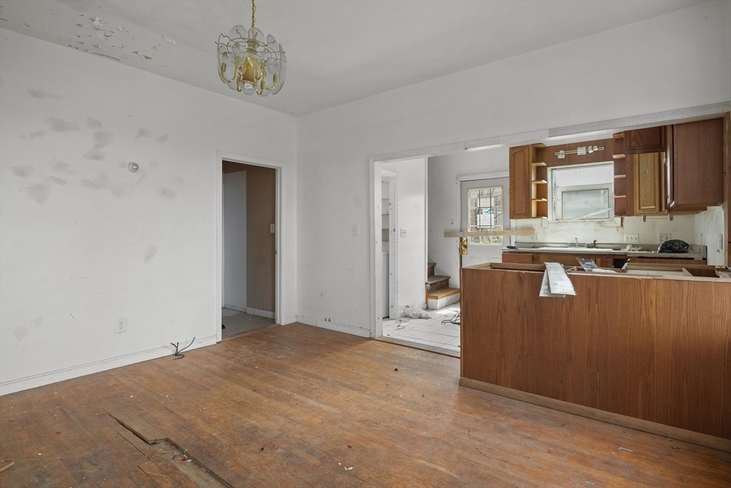 213 Weetamoe Street Fall River, MA 02720 - Photo 3 of 34 a view of a kitchen with wooden floor and a window