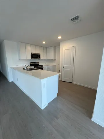 a kitchen with stainless steel appliances a refrigerator sink and microwave
