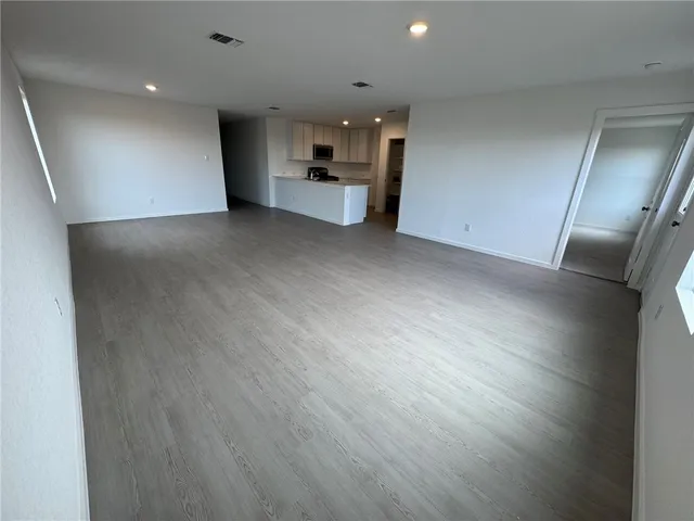an empty room with wooden floor and electronic appliances