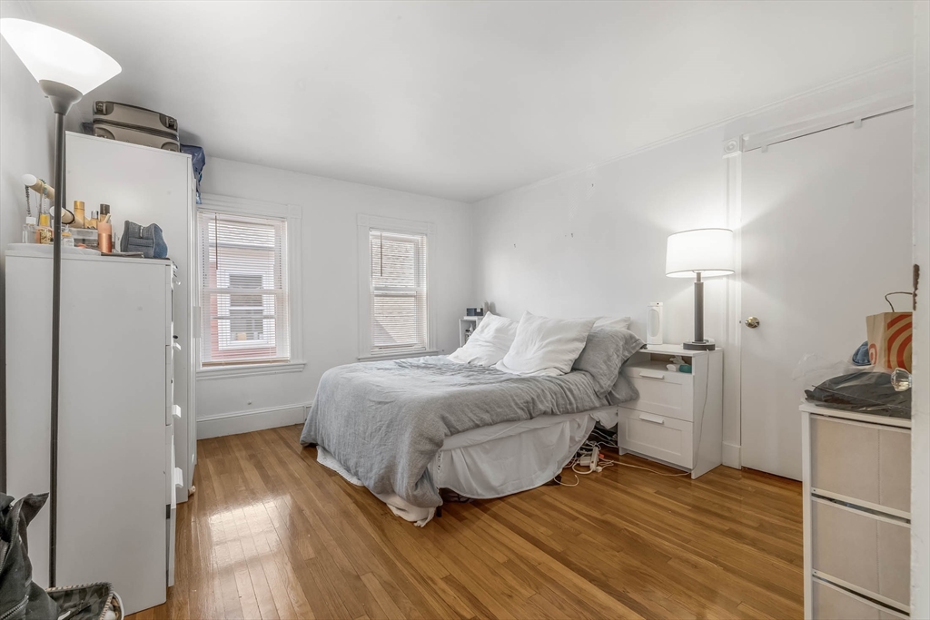 151 Magazine Street, Unit 3 Cambridge, MA 02139 - Photo 18 of 26 a bedroom with a bed and wooden floor