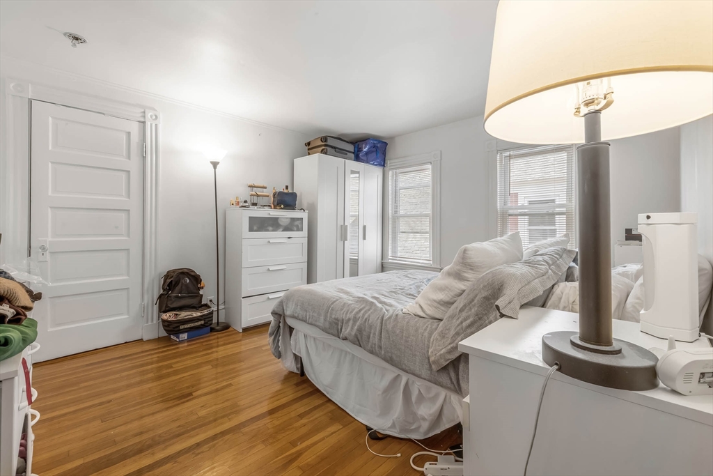 151 Magazine Street, Unit 3 Cambridge, MA 02139 - Photo 21 of 26 a bedroom with furniture and a wooden floor