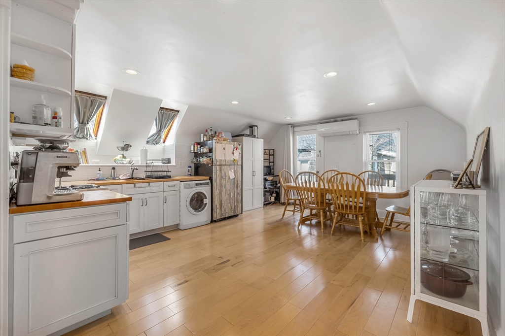 151 Magazine Street, Unit 3 Cambridge, MA 02139 - Photo 3 of 26 a kitchen with stainless steel appliances kitchen island granite countertop a table chairs sink and cabinets