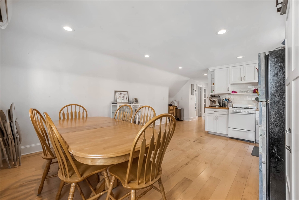 151 Magazine Street, Unit 3 Cambridge, MA 02139 - Photo 8 of 26 a kitchen with stainless steel appliances granite countertop a table chairs and a refrigerator