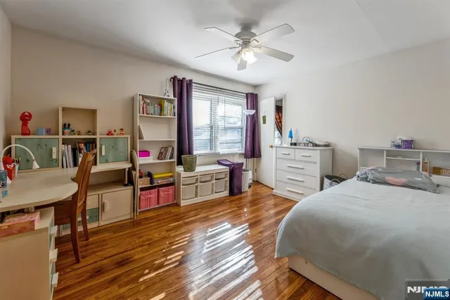 a bedroom with a bed a chandelier and a dresser
