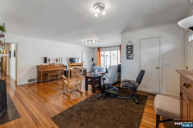 a living room with furniture a large window and wooden floor