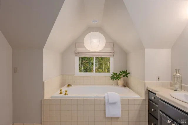 a bathroom with a tub sink and mirror