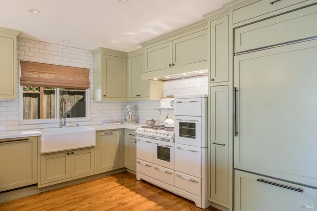 a kitchen with white cabinets and white appliances