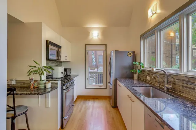 a kitchen with stainless steel appliances granite countertop a sink stove and refrigerator