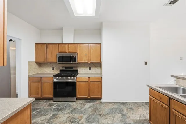 a kitchen with stainless steel appliances granite countertop a stove and a sink