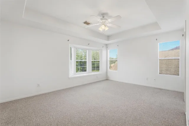 a view of an empty room with a chandelier fan