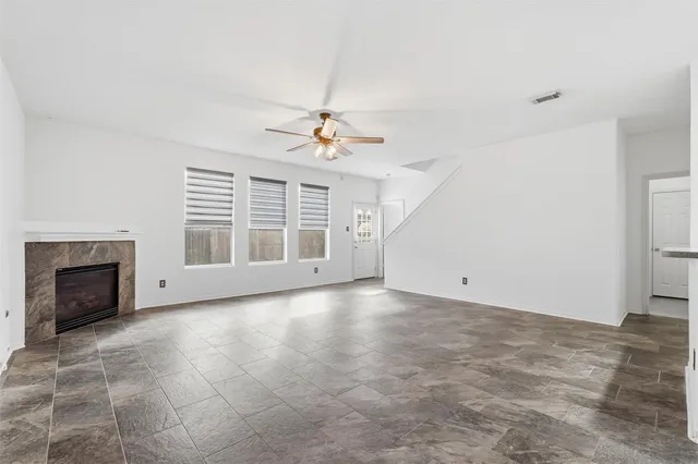 an empty room with windows and fireplace