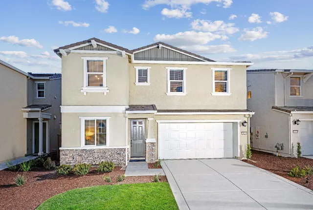 a front view of a house with a garden and plants