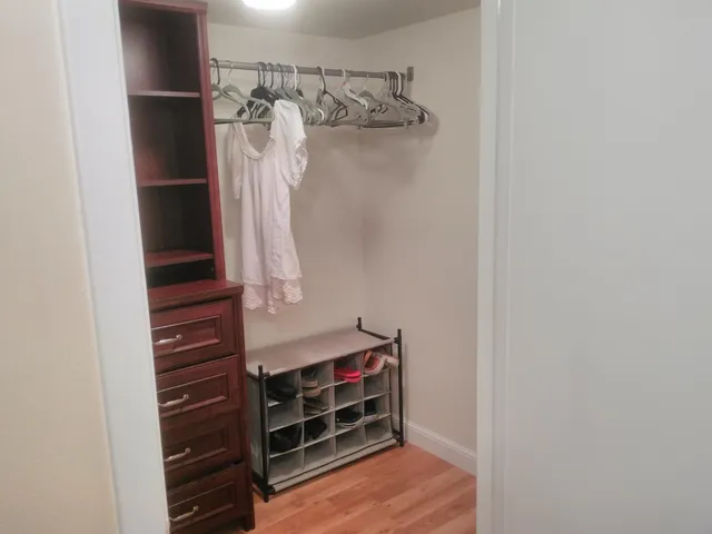 a view of walk in closet with clothes and shoes