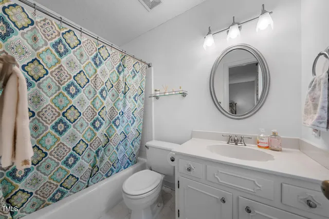 a bathroom with a granite countertop toilet sink and mirror