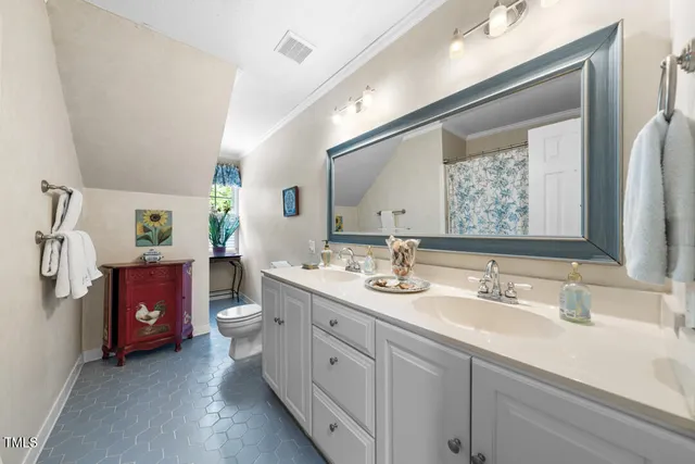 a en suite bathroom with double vanity and a mirror