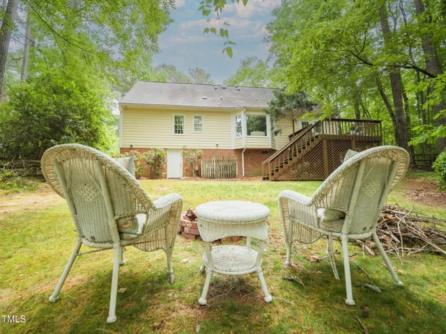 a view of a patio with table and chairs with wooden floor and fence