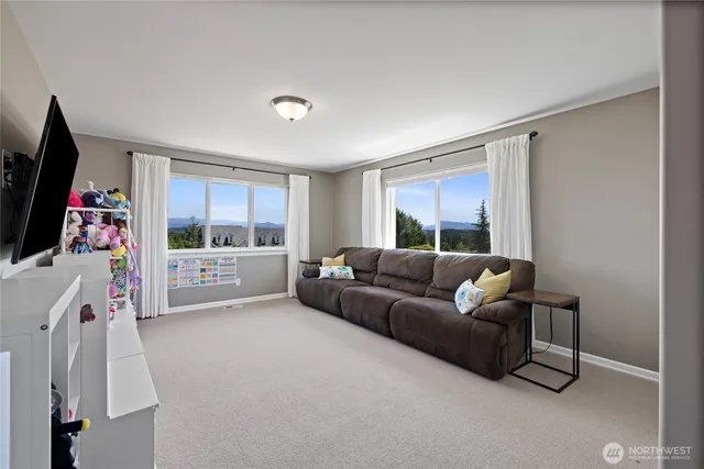 a living room with furniture a flat screen tv and a floor to ceiling window