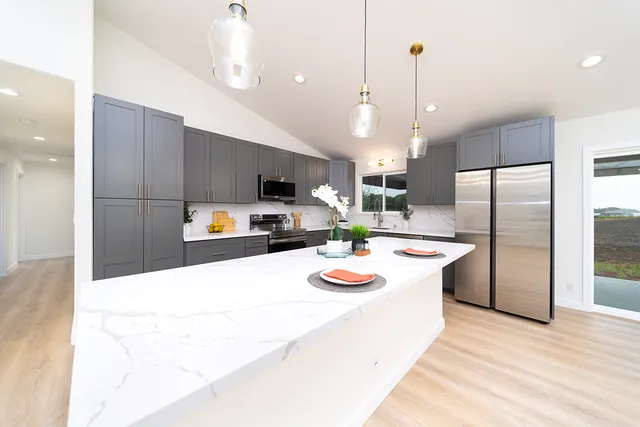 a kitchen with refrigerator and chairs