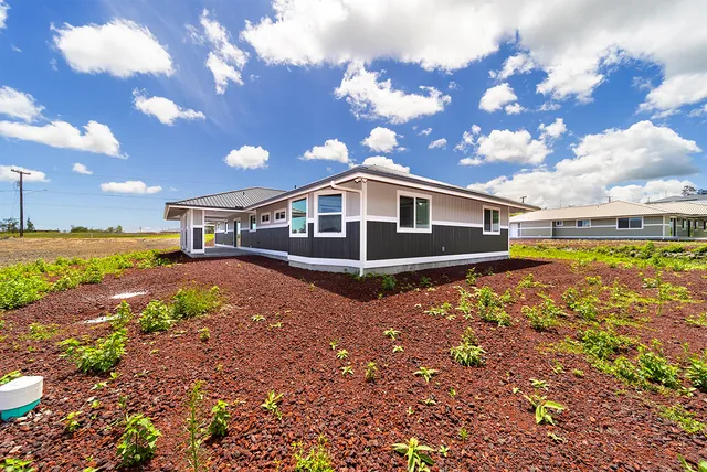 a view of a house with backyard and sitting area