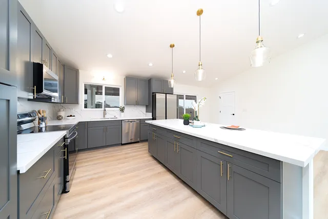 a large kitchen with kitchen island a sink stainless steel appliances and cabinets