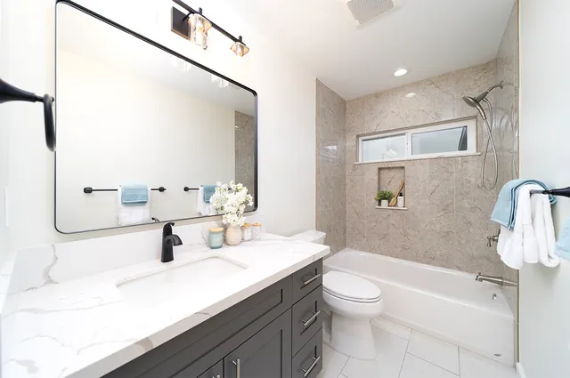 a bathroom with a sink a toilet and shower