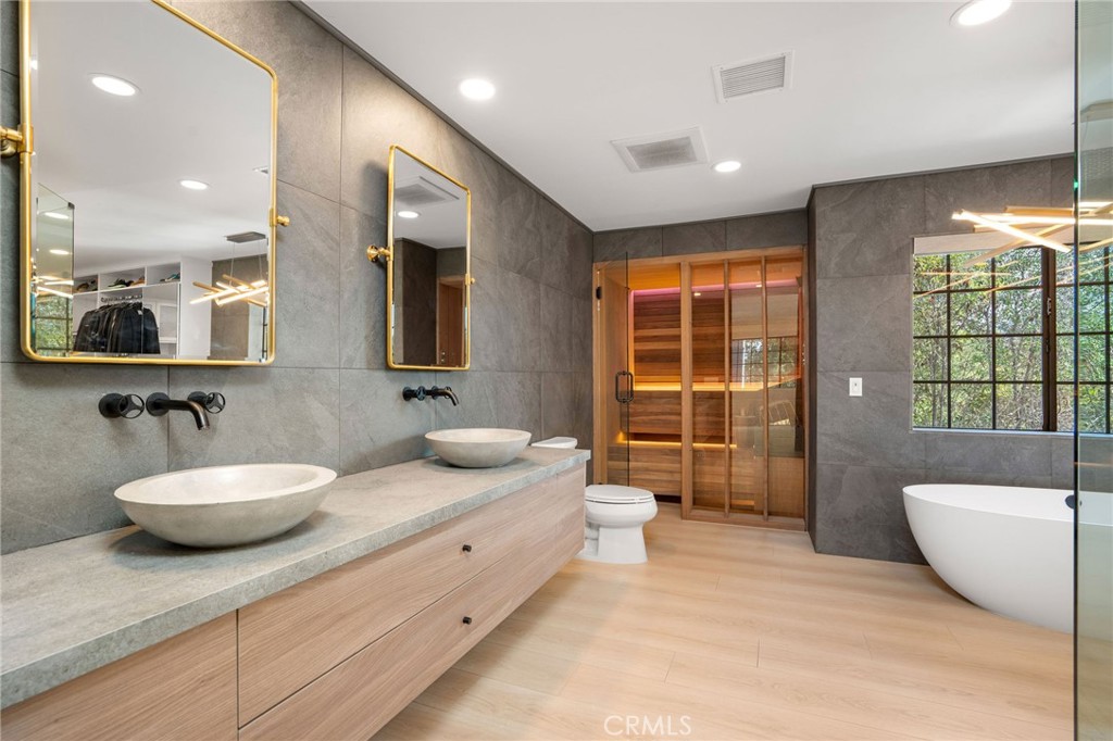 23229 8th Street Newhall, CA 91321 - Photo 41 of 52 a spacious bathroom with a double vanity sink a large mirror and a bathtub