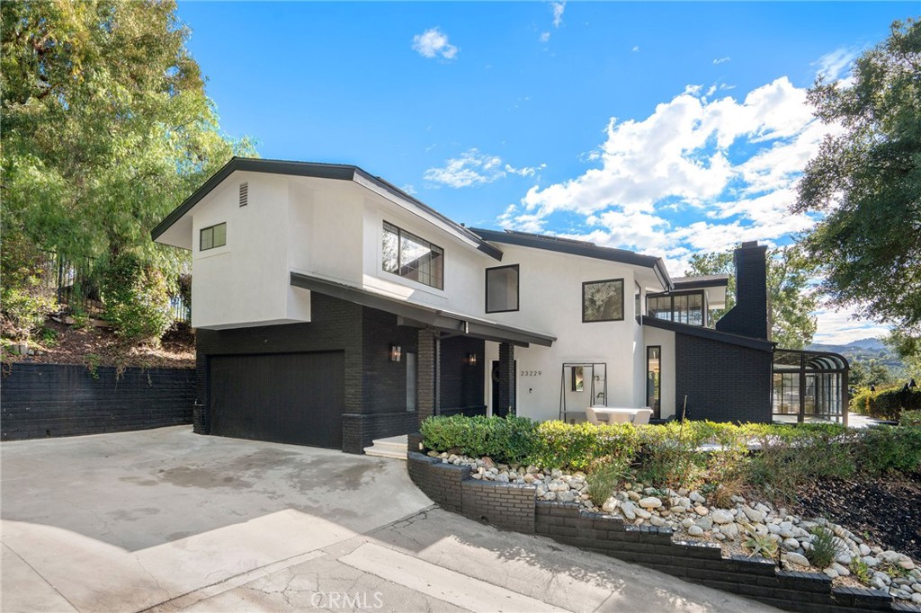 23229 8th Street Newhall, CA 91321 - Photo 6 of 52 a front view of a house with a garden
