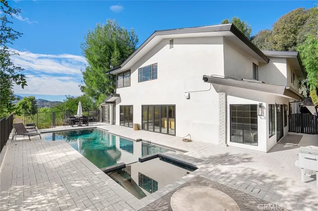 a view of a house with backyard and sitting area