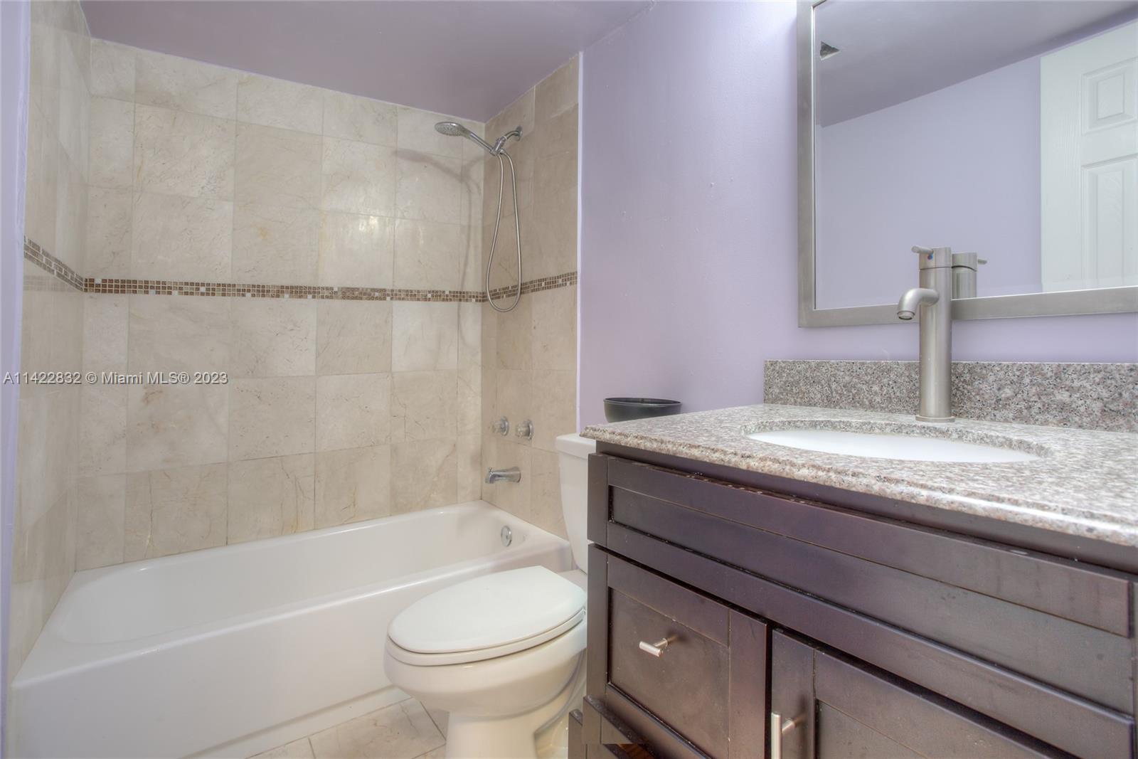 14332 Southwest 97th Lane Miami, FL 33186 - Photo 13 of 15 a bathroom with a granite countertop sink toilet and bathtub