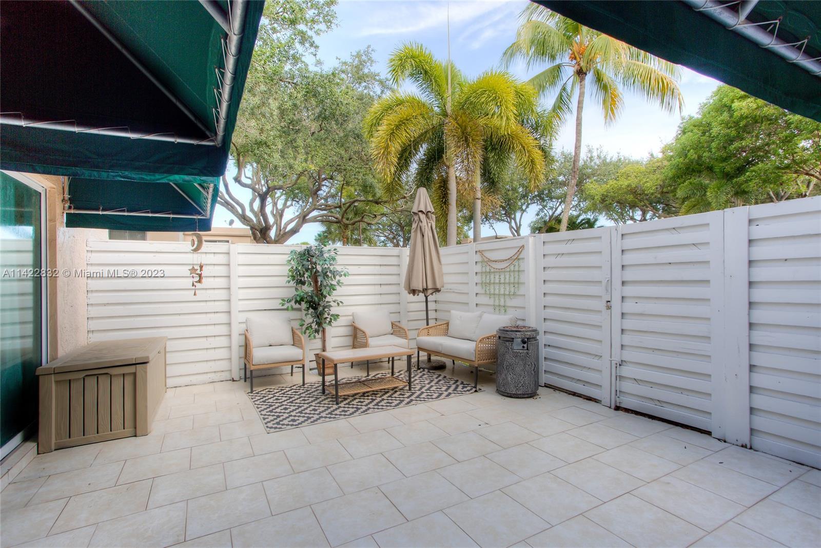14332 Southwest 97th Lane Miami, FL 33186 - Photo 14 of 15 a view of a patio with table and chairs potted plants and large tree