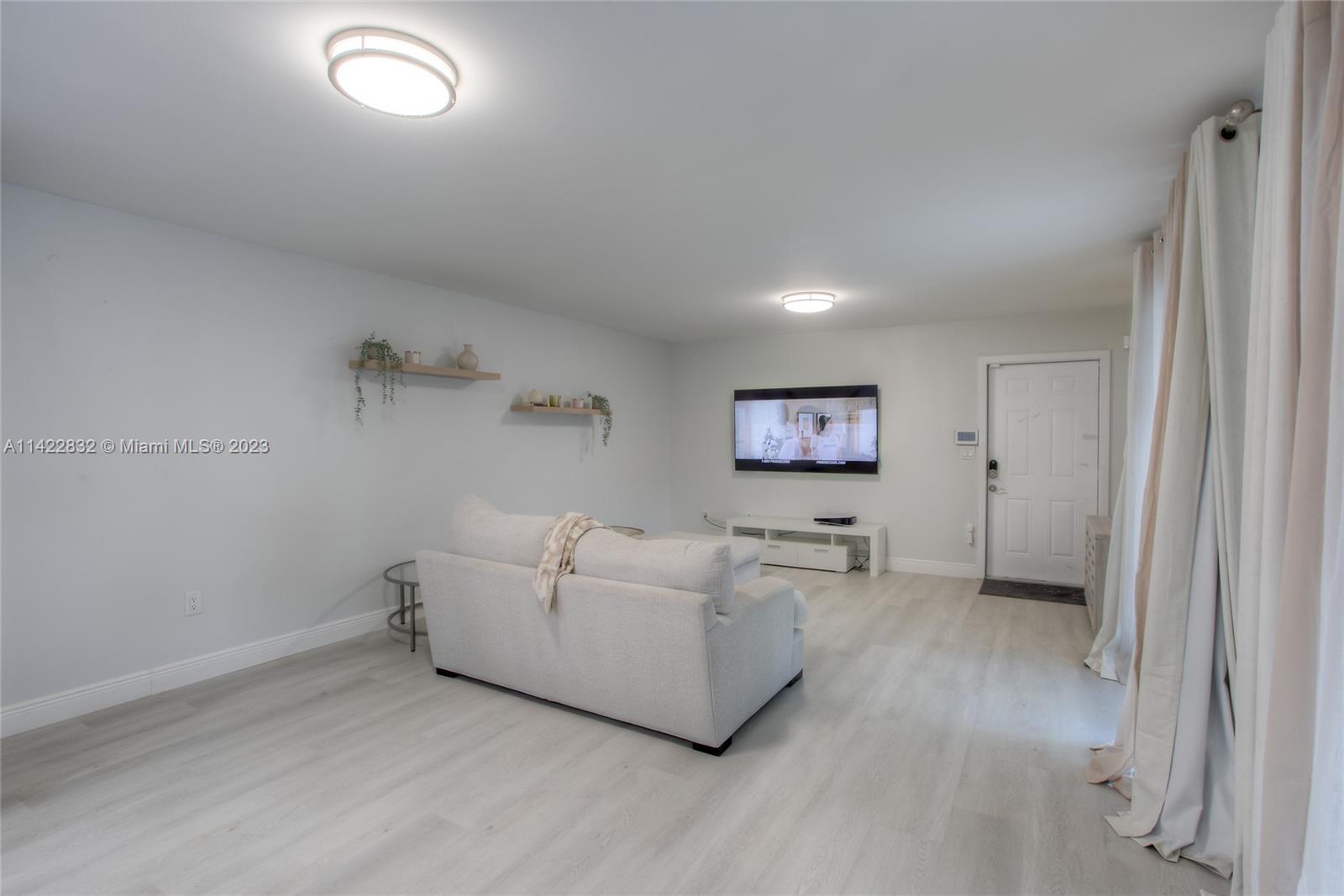 14332 Southwest 97th Lane Miami, FL 33186 - Photo 4 of 15 a living room with furniture and a flat screen tv