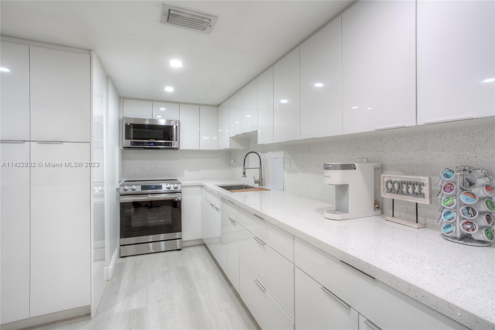 14332 Southwest 97th Lane Miami, FL 33186 - Photo 5 of 15 a kitchen with sink a stove and cabinets