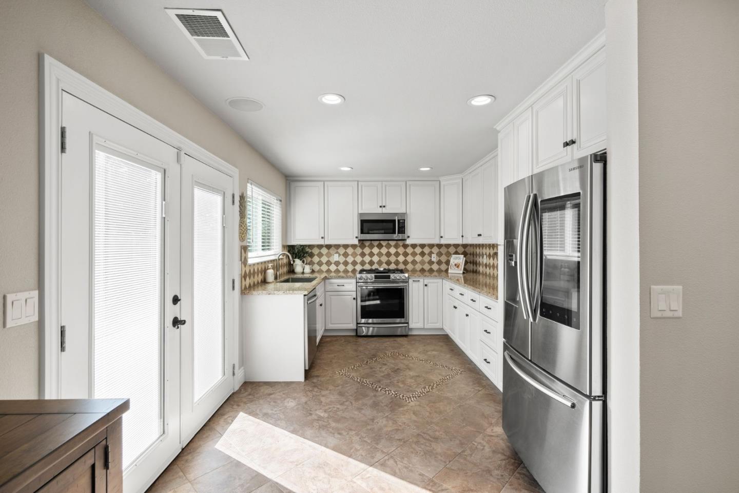 9310 Hirasaki Avenue Gilroy, CA 95020 - Photo 12 of 30 a kitchen with white cabinets and stainless steel appliances