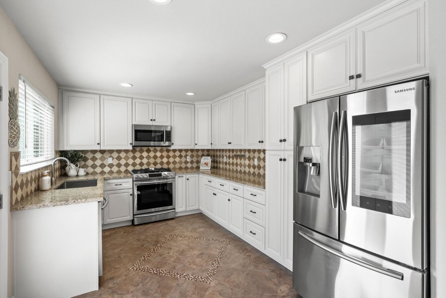 9310 Hirasaki Avenue Gilroy, CA 95020 - Photo 13 of 30 a kitchen with white cabinets and stainless steel appliances