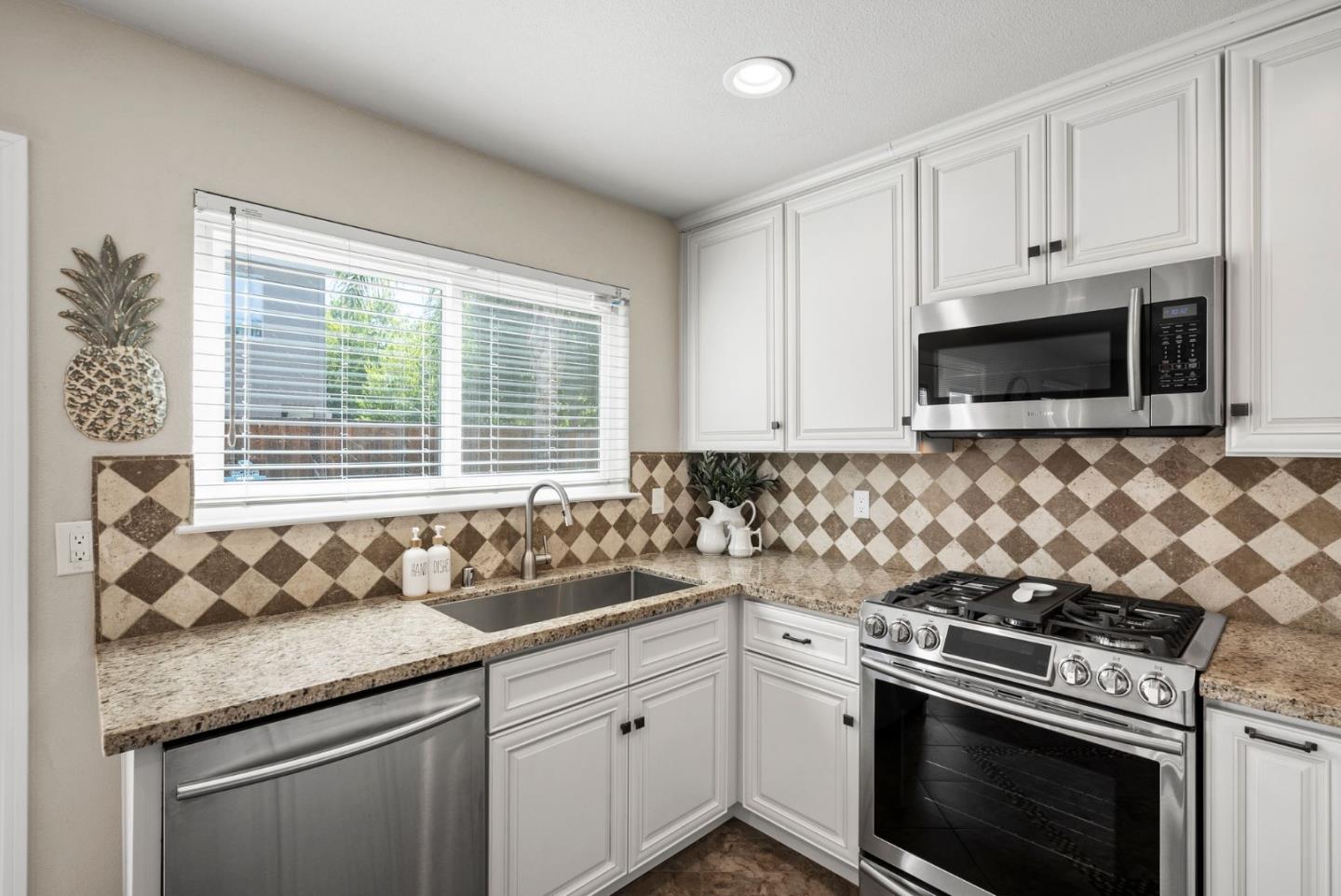 9310 Hirasaki Avenue Gilroy, CA 95020 - Photo 14 of 30 a kitchen with granite countertop a sink stove top oven and microwave
