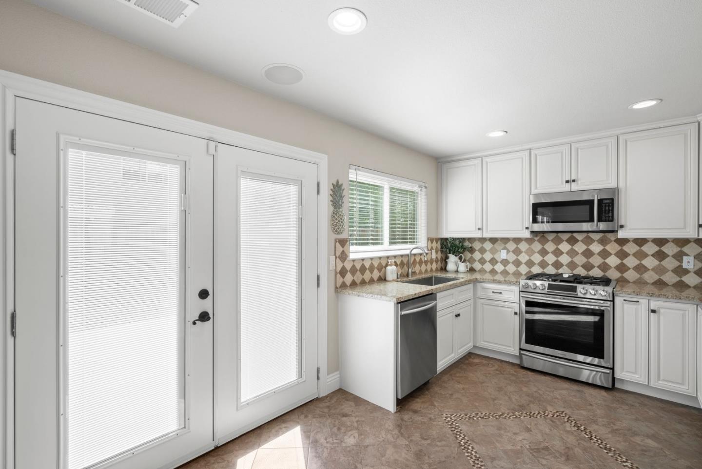 9310 Hirasaki Avenue Gilroy, CA 95020 - Photo 15 of 30 a kitchen with a stove top oven sink and cabinets