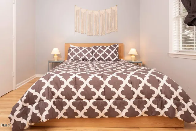 a large bed sitting in a bedroom next to a window and a lamp