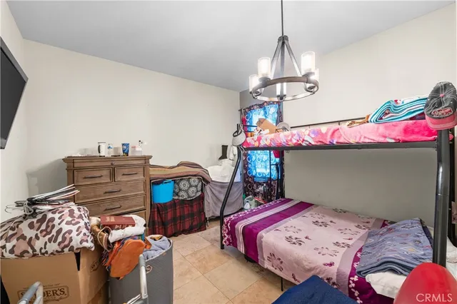 a bedroom with bed and a chandelier