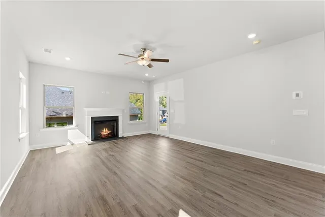 a view of an empty room with a fireplace and a window