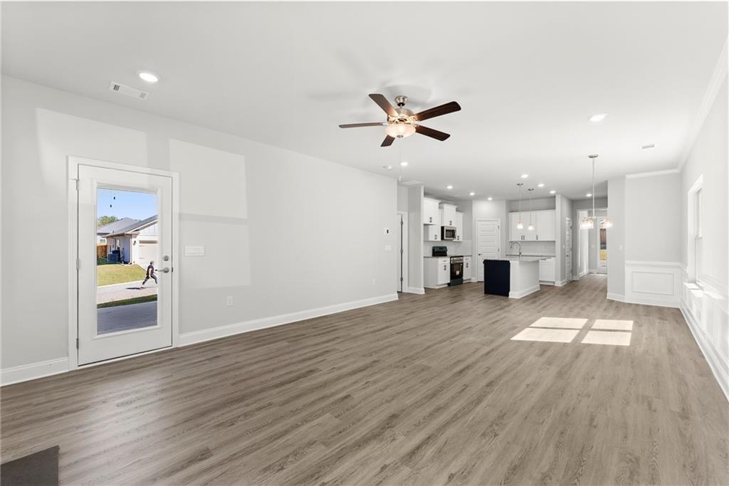 285 Magnolia Villas Drive Cornelia, GA 30531 - Photo 16 of 49 a view of empty room with wooden floor and a kitchen