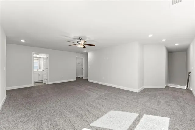 an empty room with windows and chandelier fan